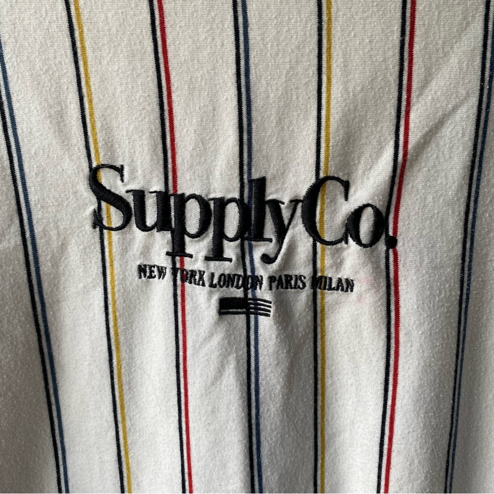 SUPPLY CO. White Loose Fit shirt with black, red, blue and yellow stripes.Size M